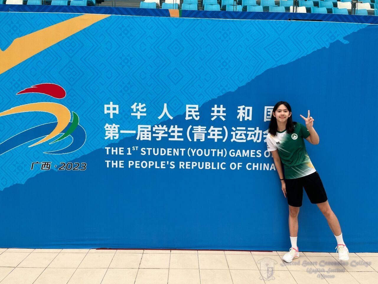 陳珮琳換裝後，在第一屆全國學生 (青年) 運動會的海報前留影，展示勝利的手勢。