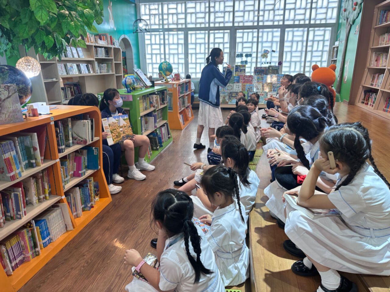 secondary students reading books with primary students 